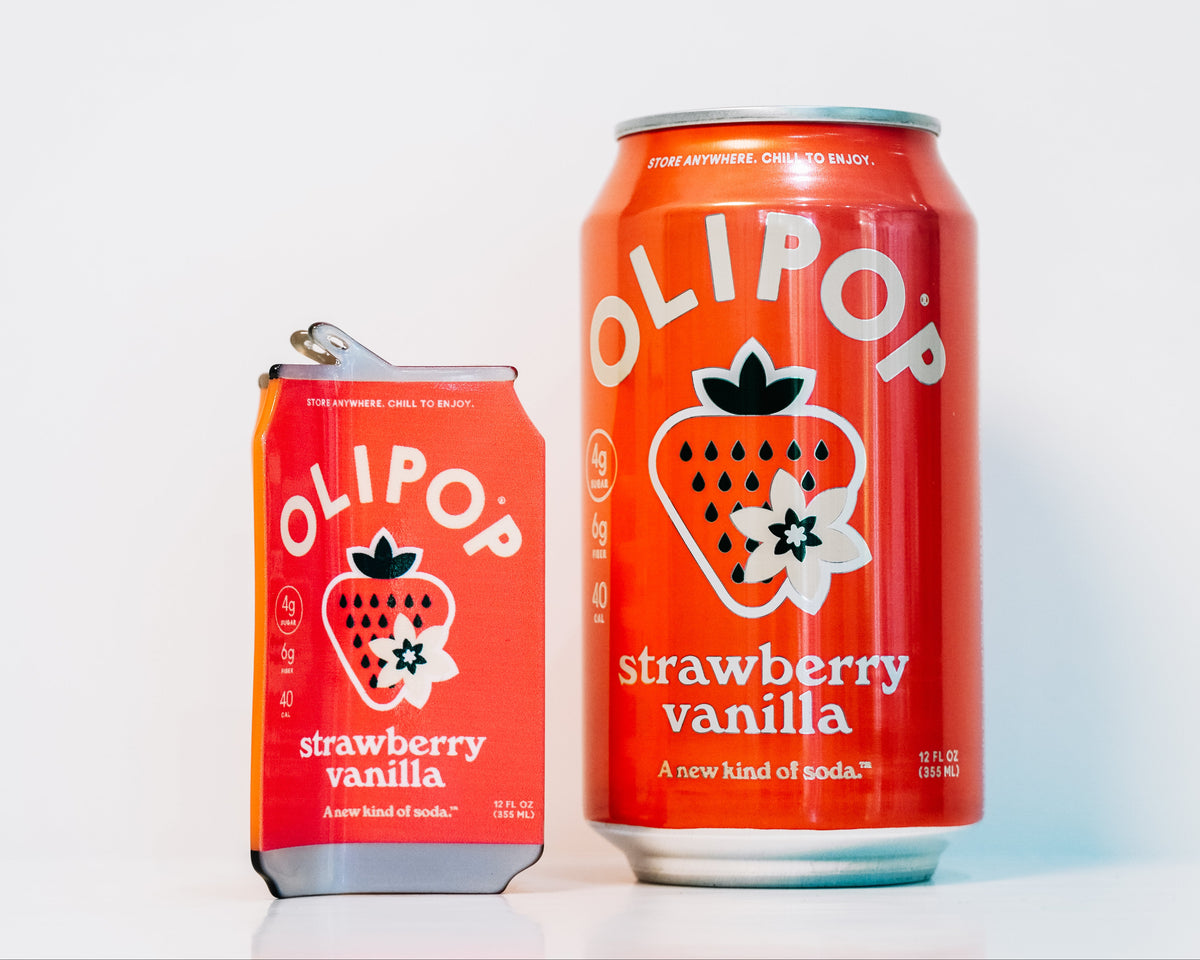 An olipop strawberry vanilla hair claw standing next to a can of strawberry vanilla olipop