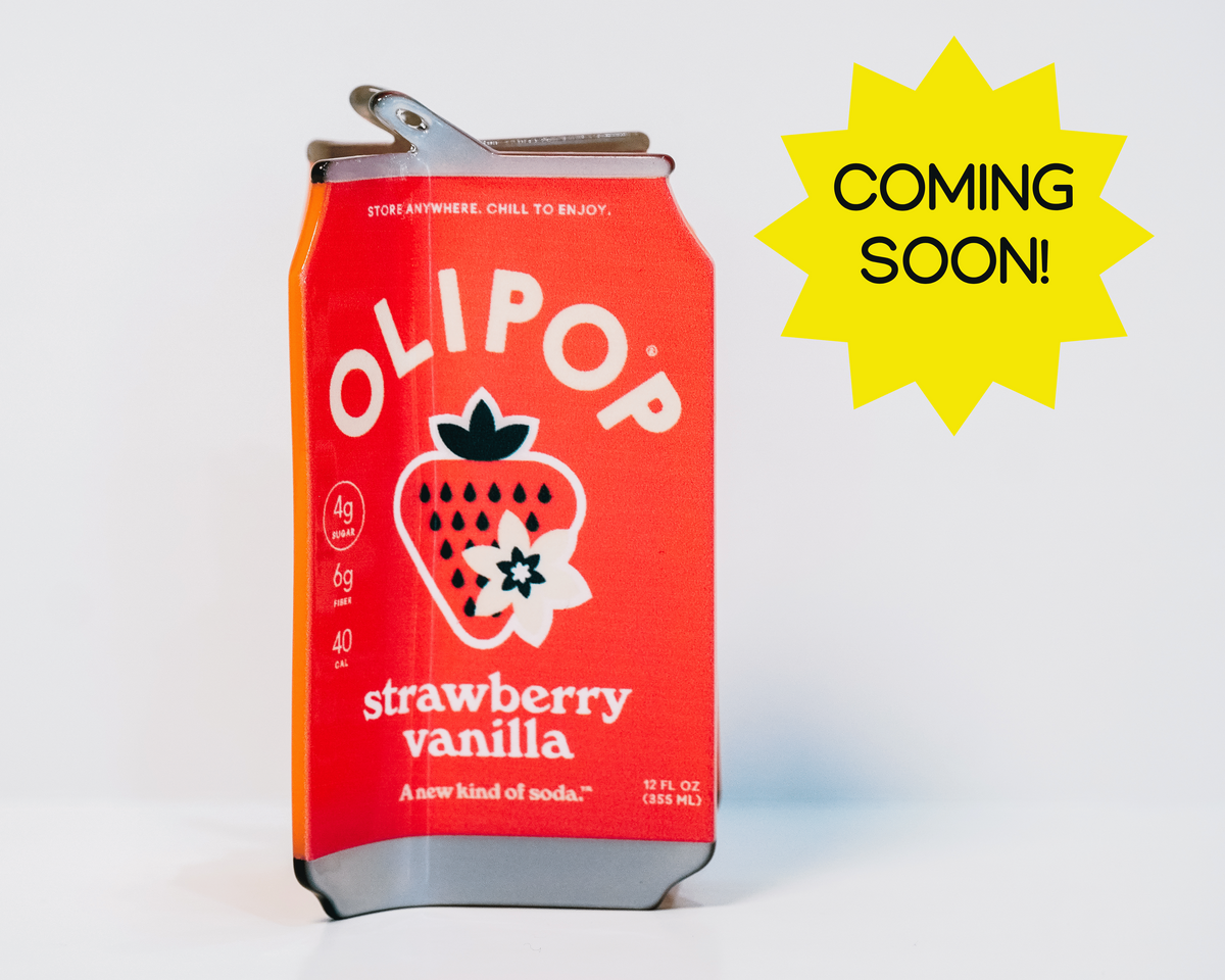 A red OLIPOP strawberry vanilla hair claw on a white background with a yellow 'COMING SOON!' starburst graphic overlay.