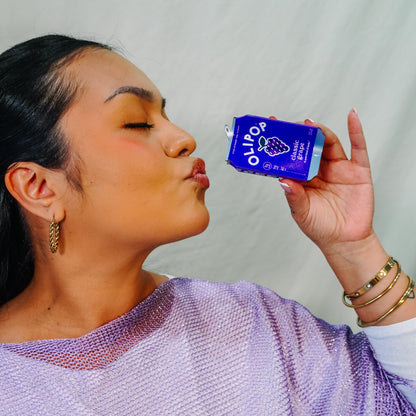 A woman pretending to drink from the Olipop Classic Grape Hair Claw