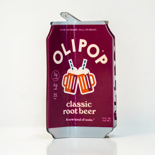 a hair claw designed to look like an OLIPOP classic root beer can with a metallic burgundy label and silver top/bottom. the design features the OLIPOP branding and drink information, as well as an illustration of two root beer glasses